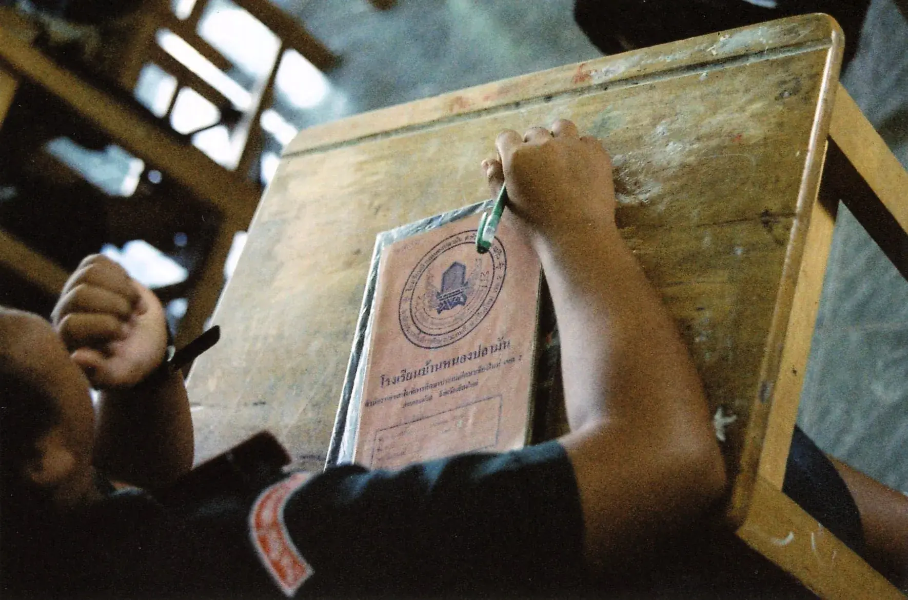 A teacher leading an English lesson with students in a Thai school classroom.