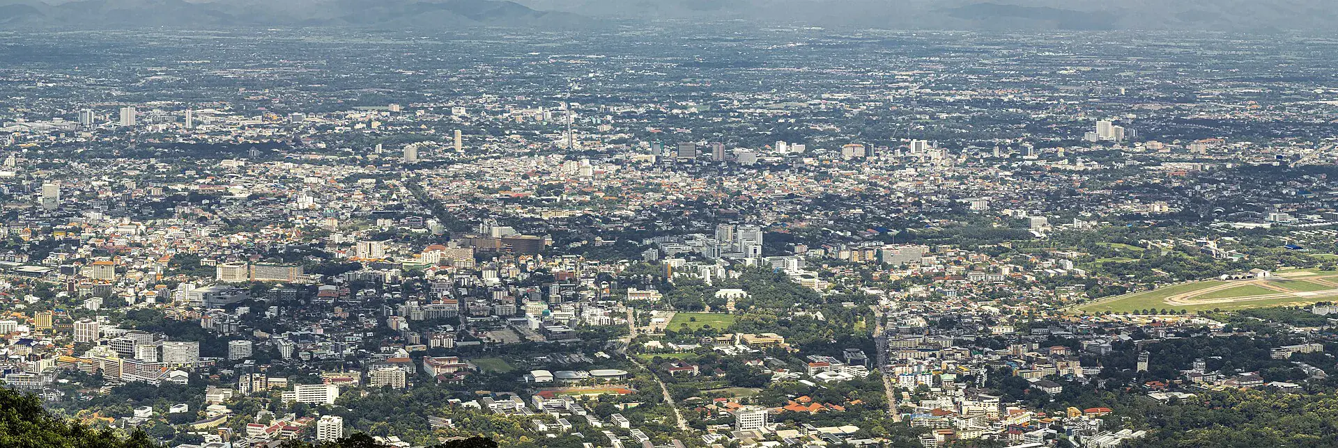 Panoramic view across Chiang Mai city toward surrounding mountains from Doi Suthep.